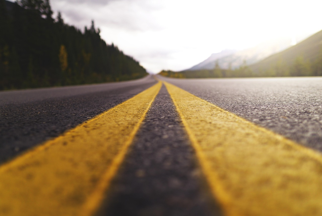 centerline of road with mountains and trees