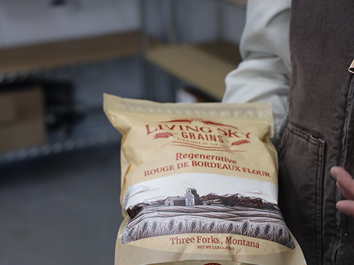 Franck Groeneweg shows off a bag of Living Sky Grains Rouge de Bordeaux Flour