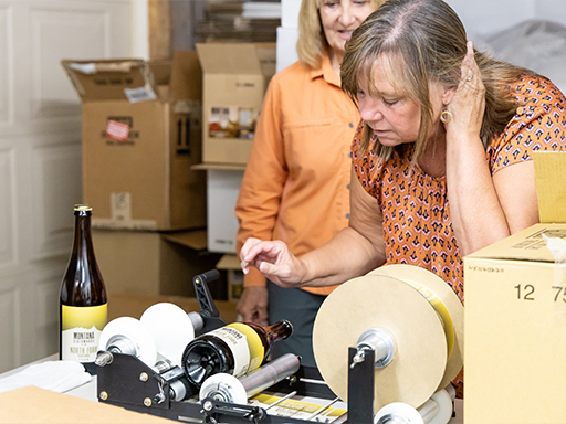 Director Clark labels a bottle of Montana Ciderworks cider in Darby, Montana